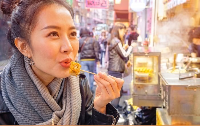 Eating a freshly fried street-food snack at a stall